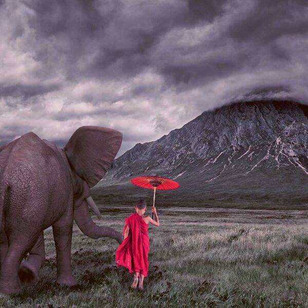 An elephant gently holding a girl’s hand as she walks with a red umbrella, with stormy skies and a misty mountain in the background