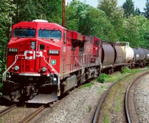 Red Canadian train locomotive on tracks, perfect for displaying in an LED Box Frame for train collectors.