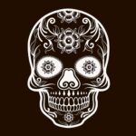 Detailed white candy skull design with floral accents on a dark background.