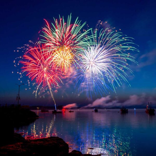 A breathtaking fireworks display captured at night, with vibrant colors and reflections over the water, presented in a customizable LED Box Frame for an eco-friendly, energy-efficient lighting experience.